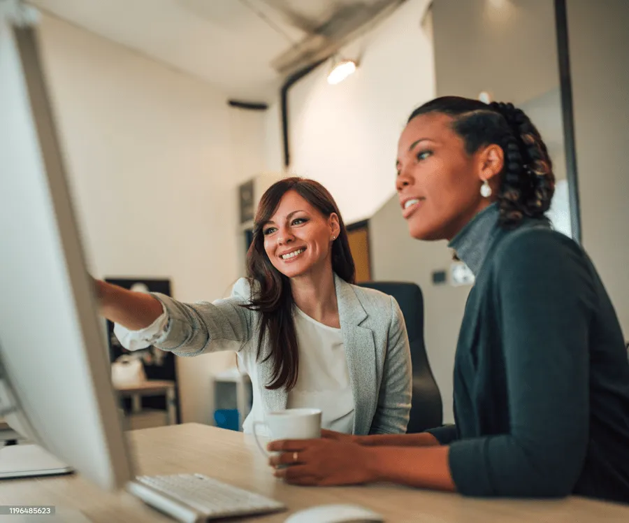 Admin and employee look at data on a screen together
